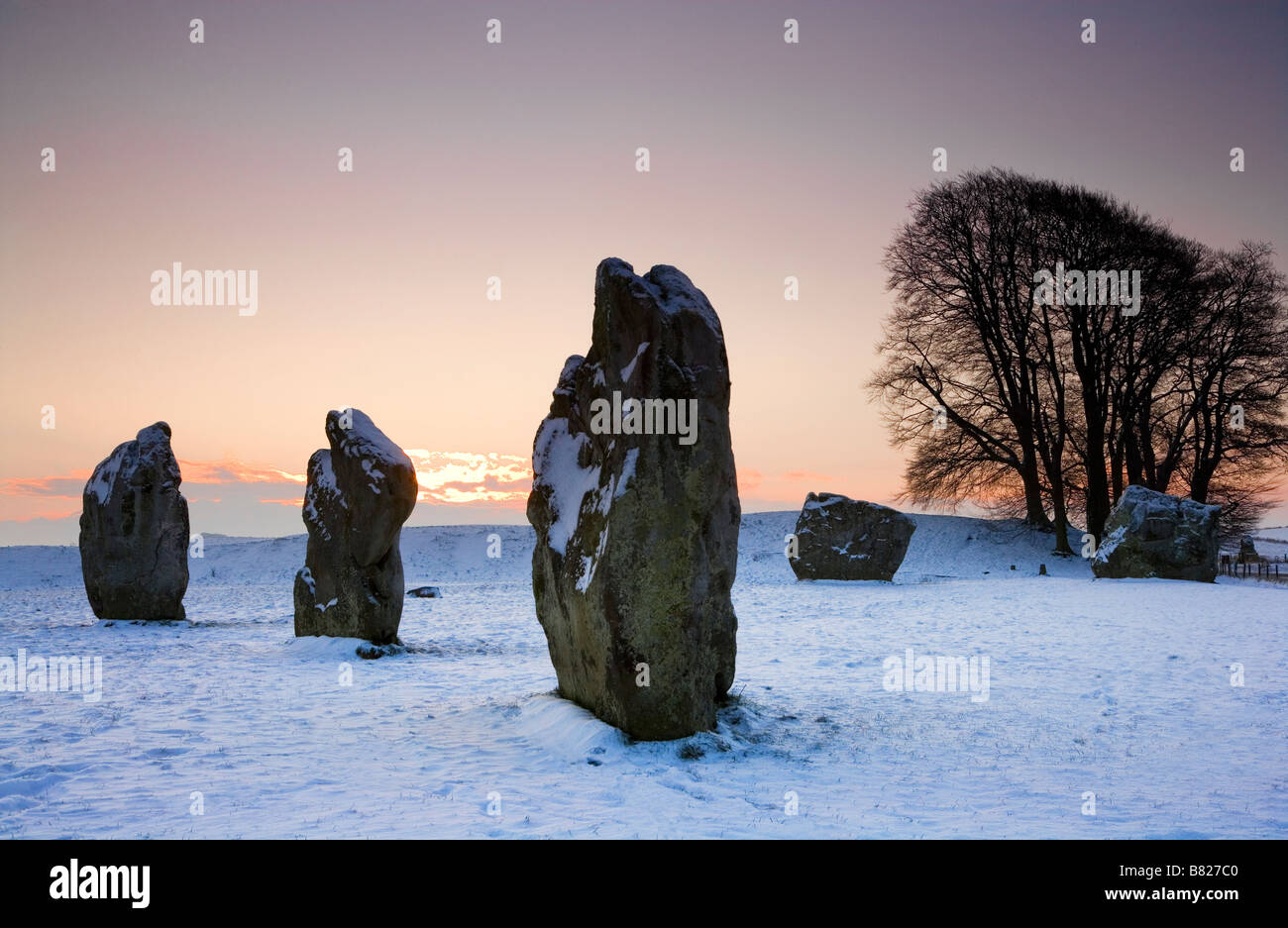 Un lever de soleil sur l'hiver neigeux pierres sarsen à Avebury dans le Wiltshire England UK Banque D'Images