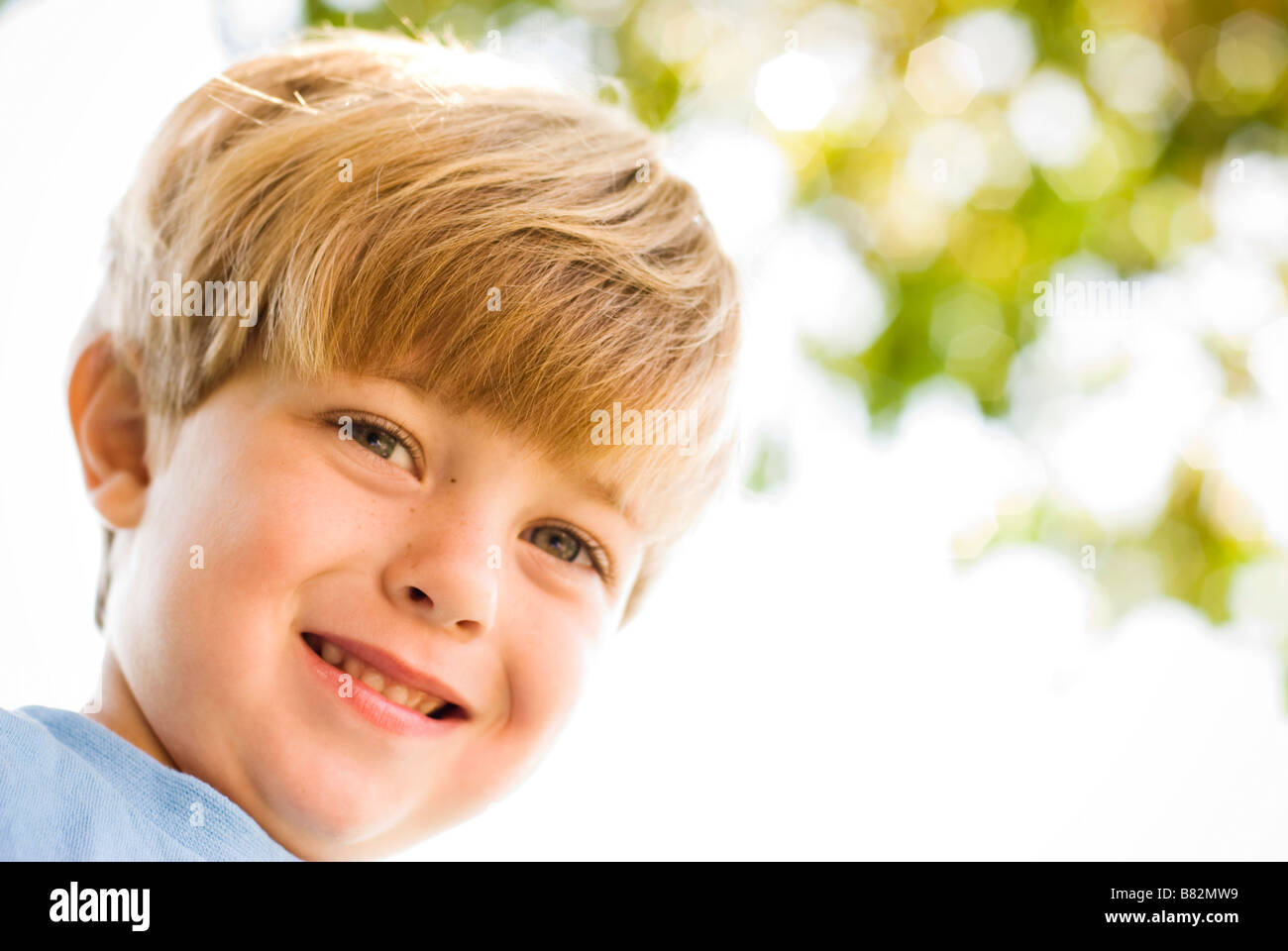 Boy smiling outdoors jouant Banque D'Images
