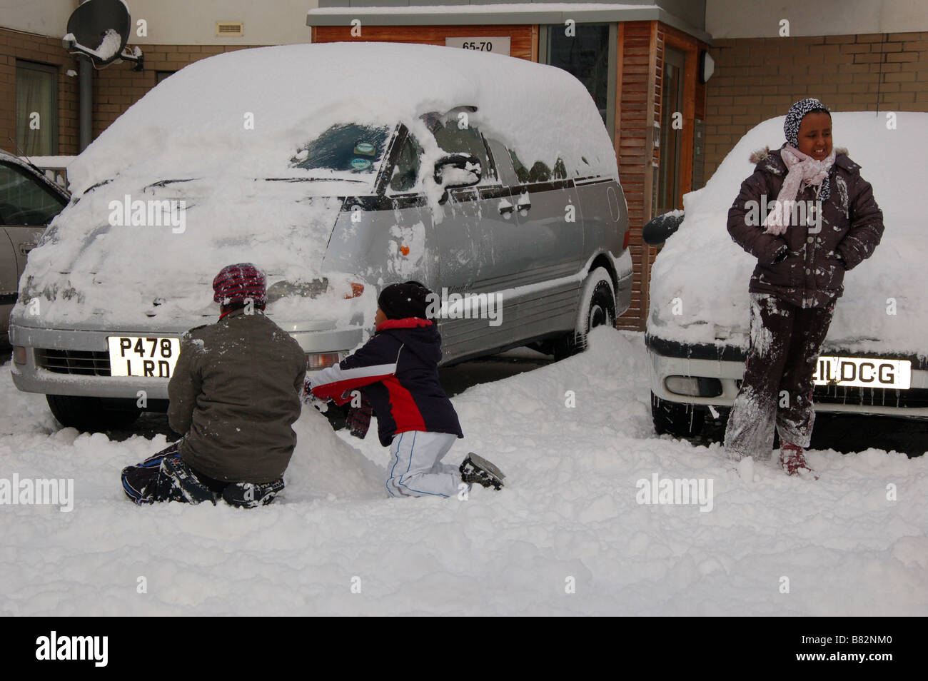 Enfants jouant avec la neige durant l'hiver à Colindale, London, England, UK Banque D'Images