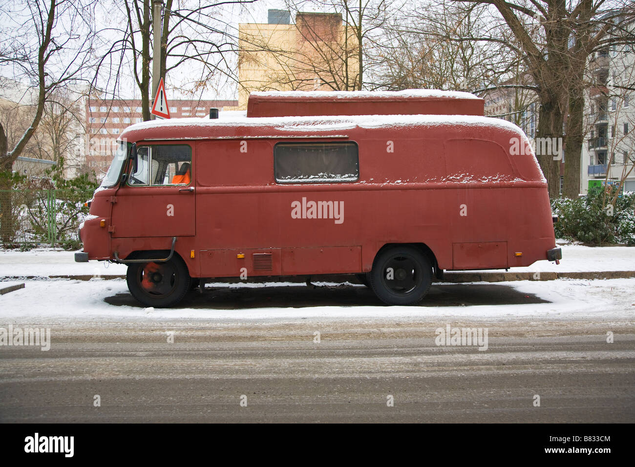 Le camping-car dans la neige rouge Banque D'Images