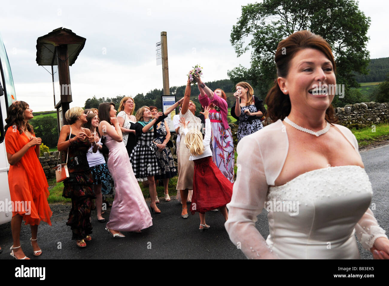 La mariée jette son bouquet pour les invités au mariage le North Yorkshire Banque D'Images