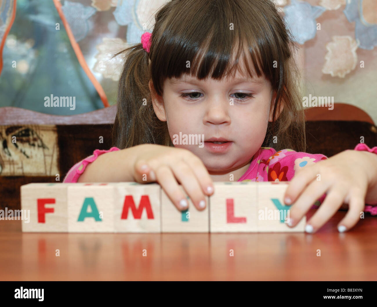 La fille et l'enfant cubes jouet la collecte d'une famille de mots à partir de cubes Banque D'Images