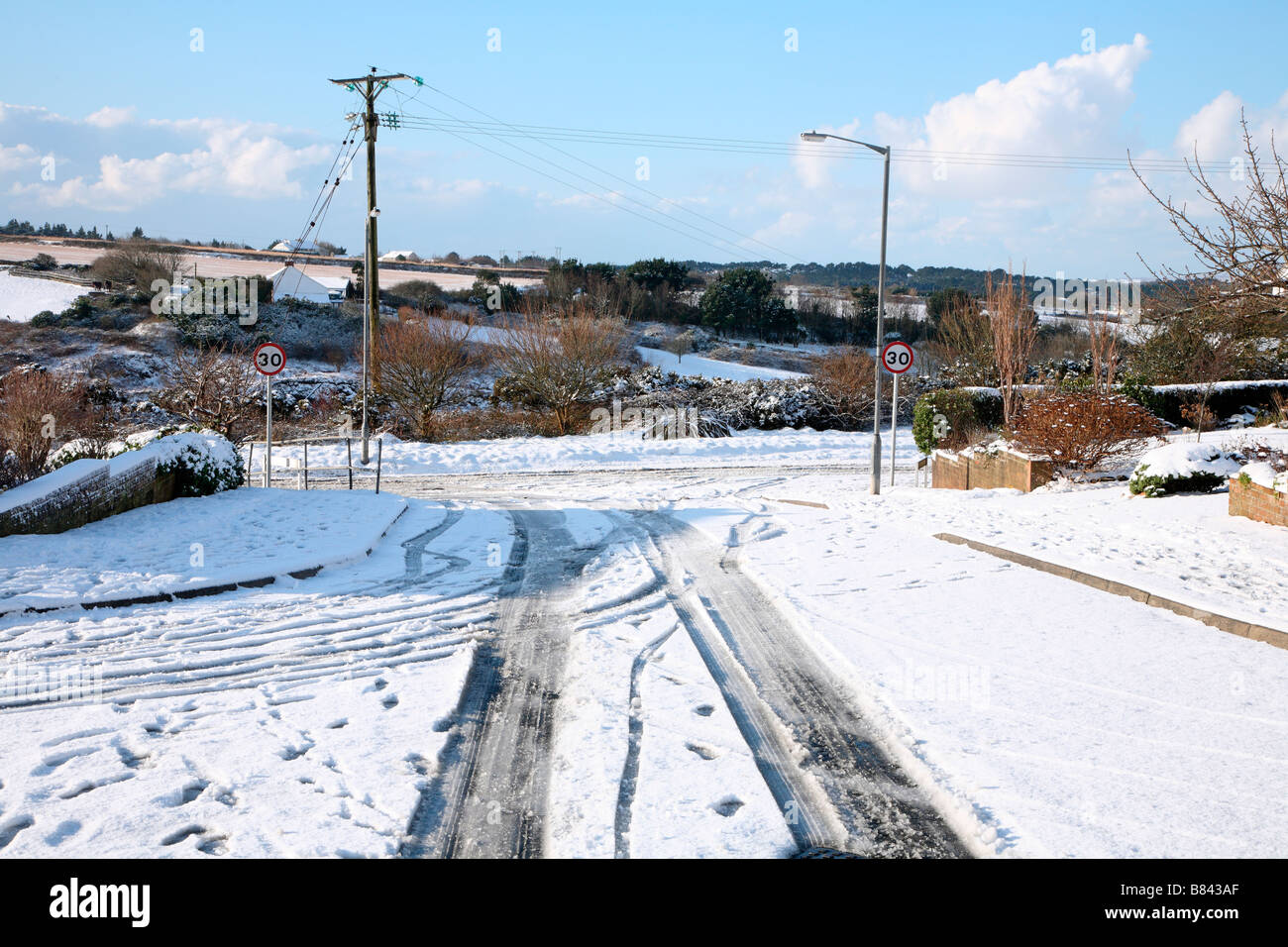 La neige et de la glace sur une route dans un lotissement à Cornwall, UK. Banque D'Images