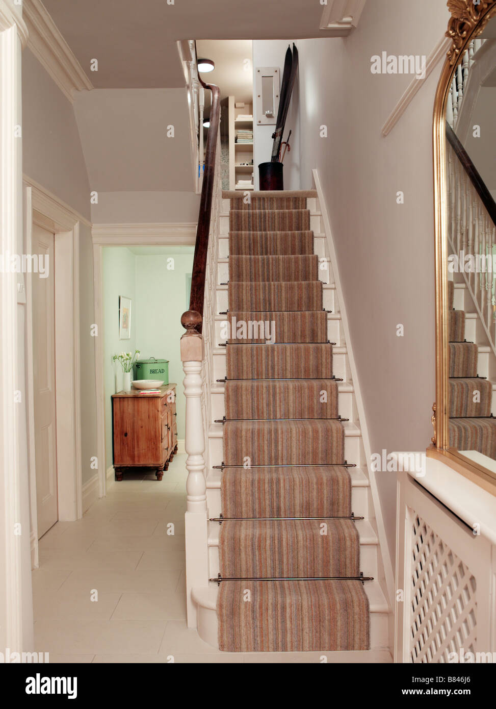 Entrée avec escalier et tapis à rayures Banque D'Images