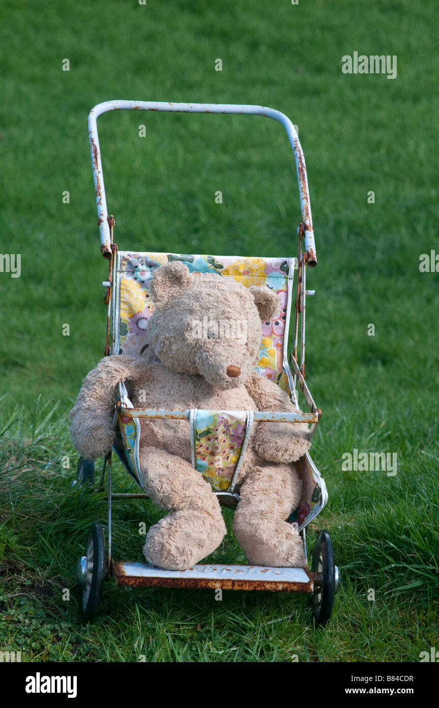 Un ours en peluche préféré dans une vieille poussette d'enfants Banque D'Images