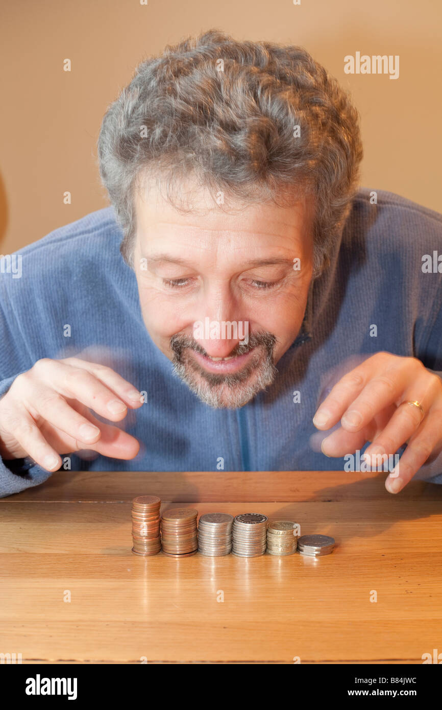 Un homme avare en comptant son argent Banque D'Images