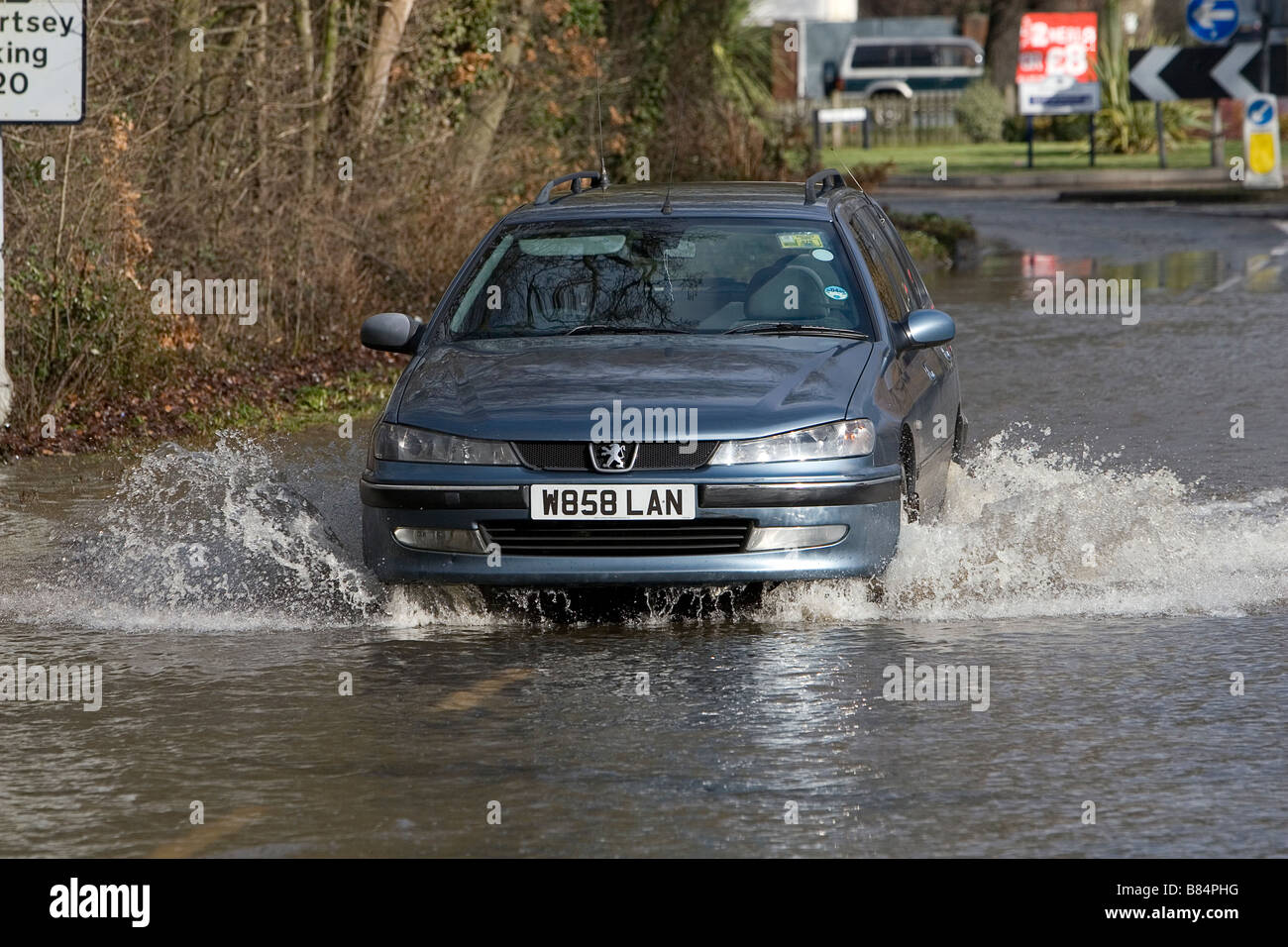 Voiture roulant à travers l'eau d'inondation dans la région de Chertsey Banque D'Images