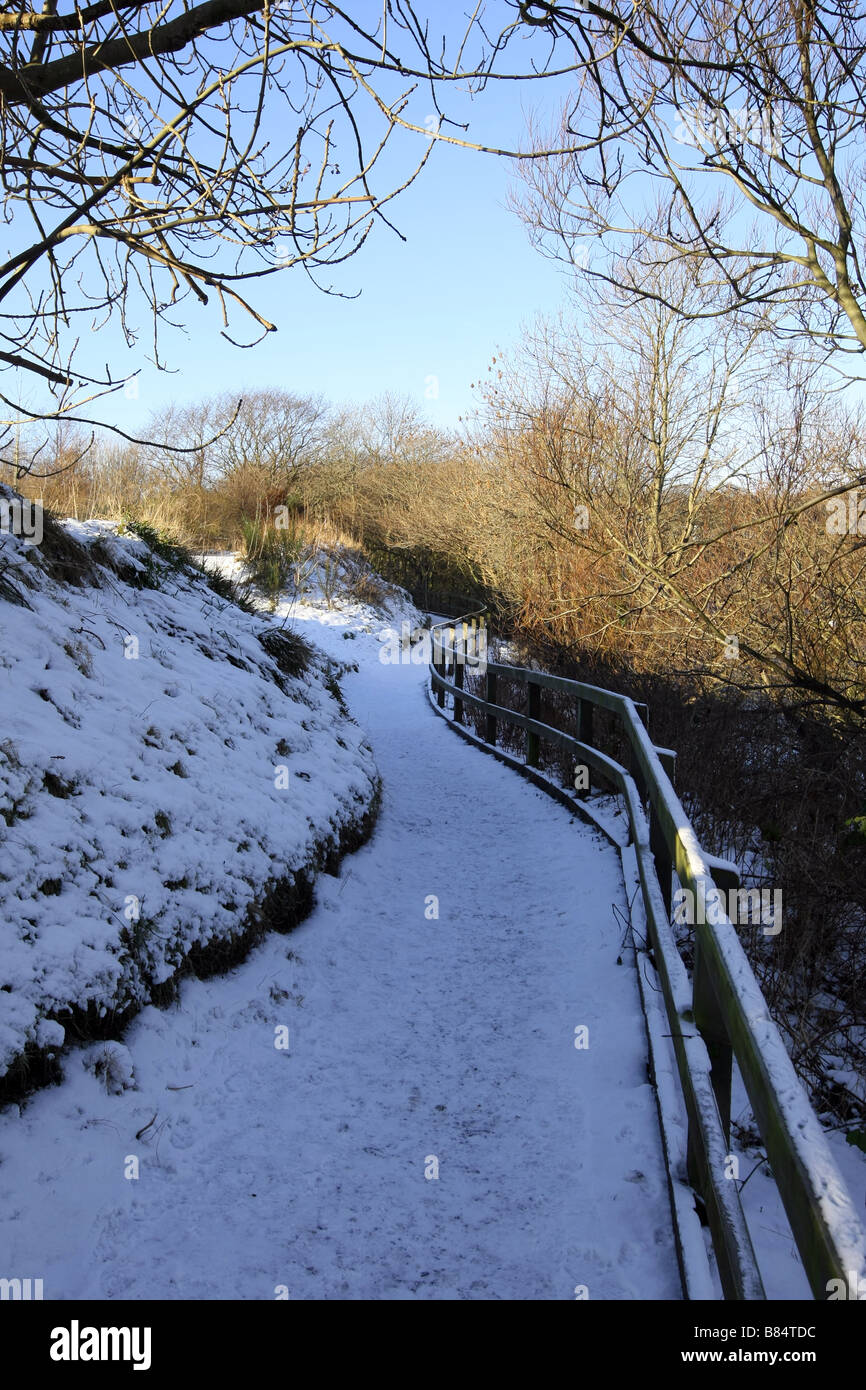 Sentier à Donmouth à côté de la rivière Don dans la ville d'Aberdeen, Écosse, Royaume-Uni au cours de l'hiver avec la neige sur les rives du fleuve. Banque D'Images