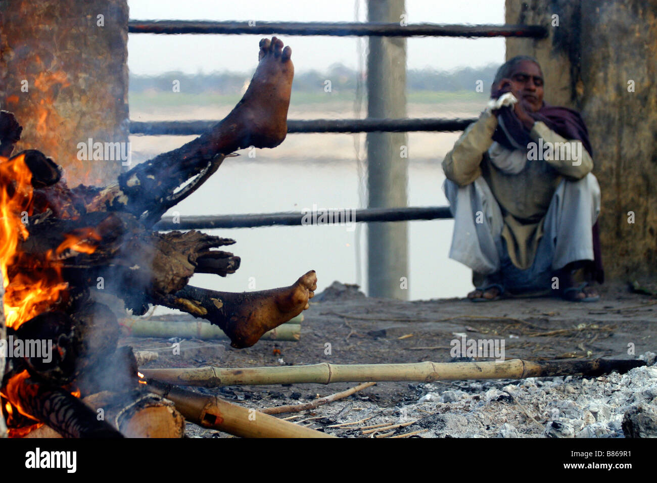 Un corps est en train de brûler sur un bûcher sur un ghat le long du Gange dans la ville sainte de Varanasi en Inde Banque D'Images