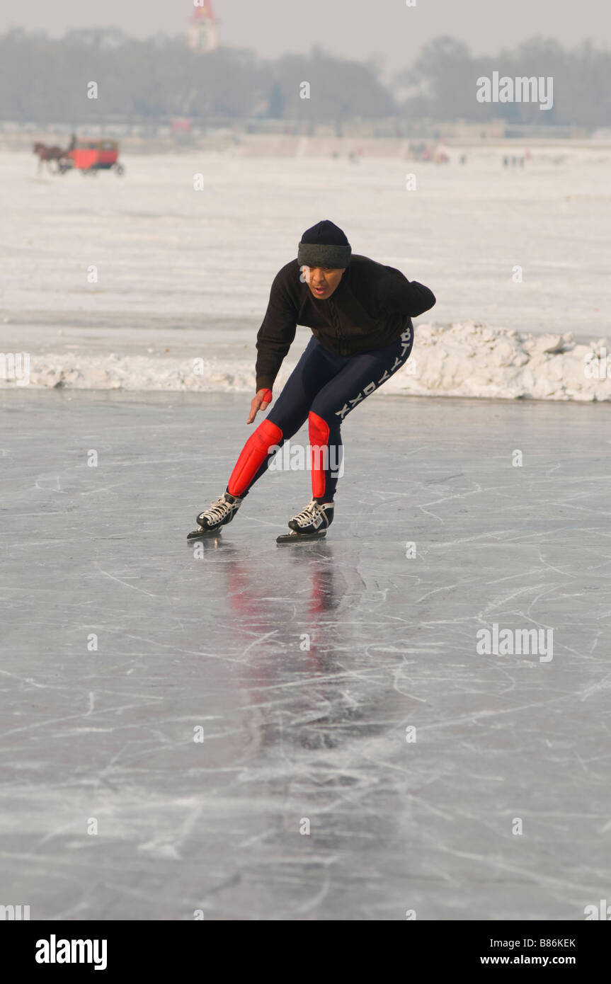 Les pratiques d'un homme sur le patinage de vitesse de rivière Songhua gelé, Harbin, province de Heilongjiang, Chine 2009 Banque D'Images