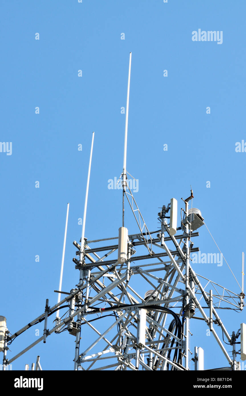 Partie supérieure d'une tour de téléphonie cellulaire contre le ciel bleu clair montrant antennes pour transmettre des signaux de téléphone mobile cellulaire USA Banque D'Images
