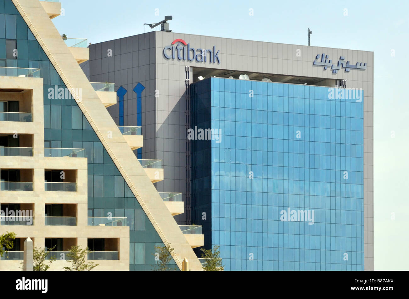 Panneaux de marque avec logo bilingue sur le toit en haut du bâtiment de bureaux Citibank de Dubaï et panneaux de revêtement en verre teinté dans les Émirats arabes Unis au Moyen-Orient Banque D'Images