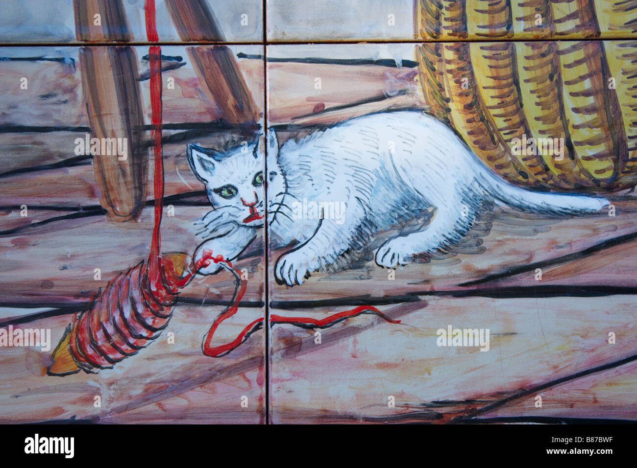 Carrelages dans village sur Gran Canaria illustrant chat jouant avec balle de laine. Banque D'Images