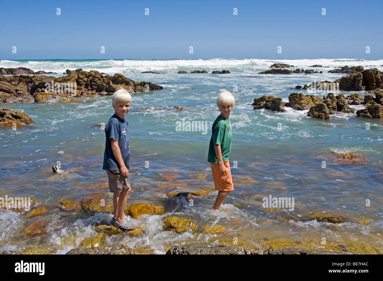 Deux garçons debout à l'extrémité sud du continent africain les roches à Cap des aiguilles en Afrique du Sud Banque D'Images