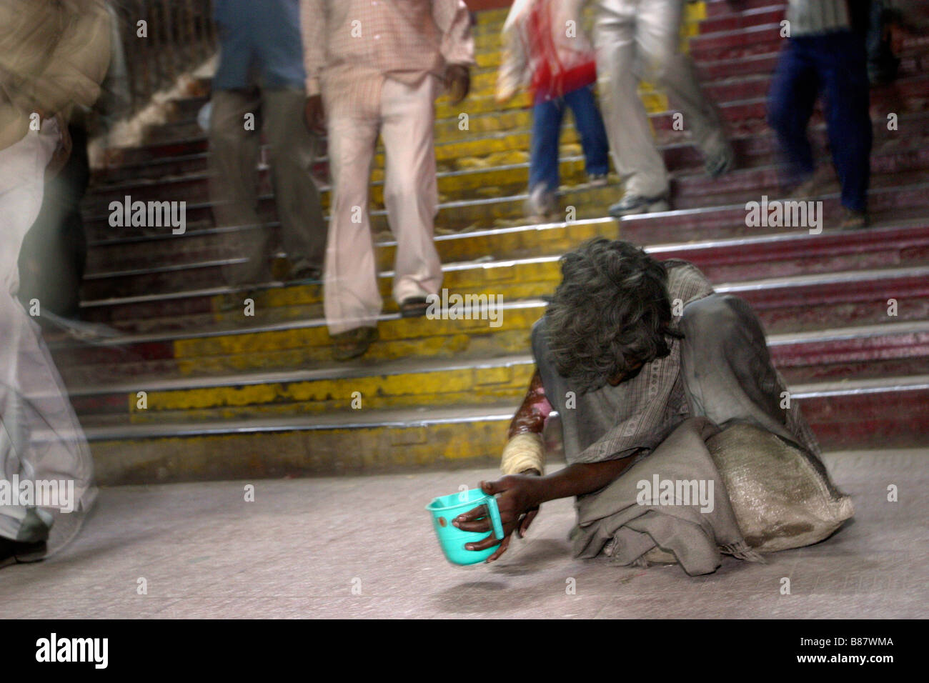 Un Indien mendiant mendie de l'argent dans un métro à New Delhi en Inde. Banque D'Images