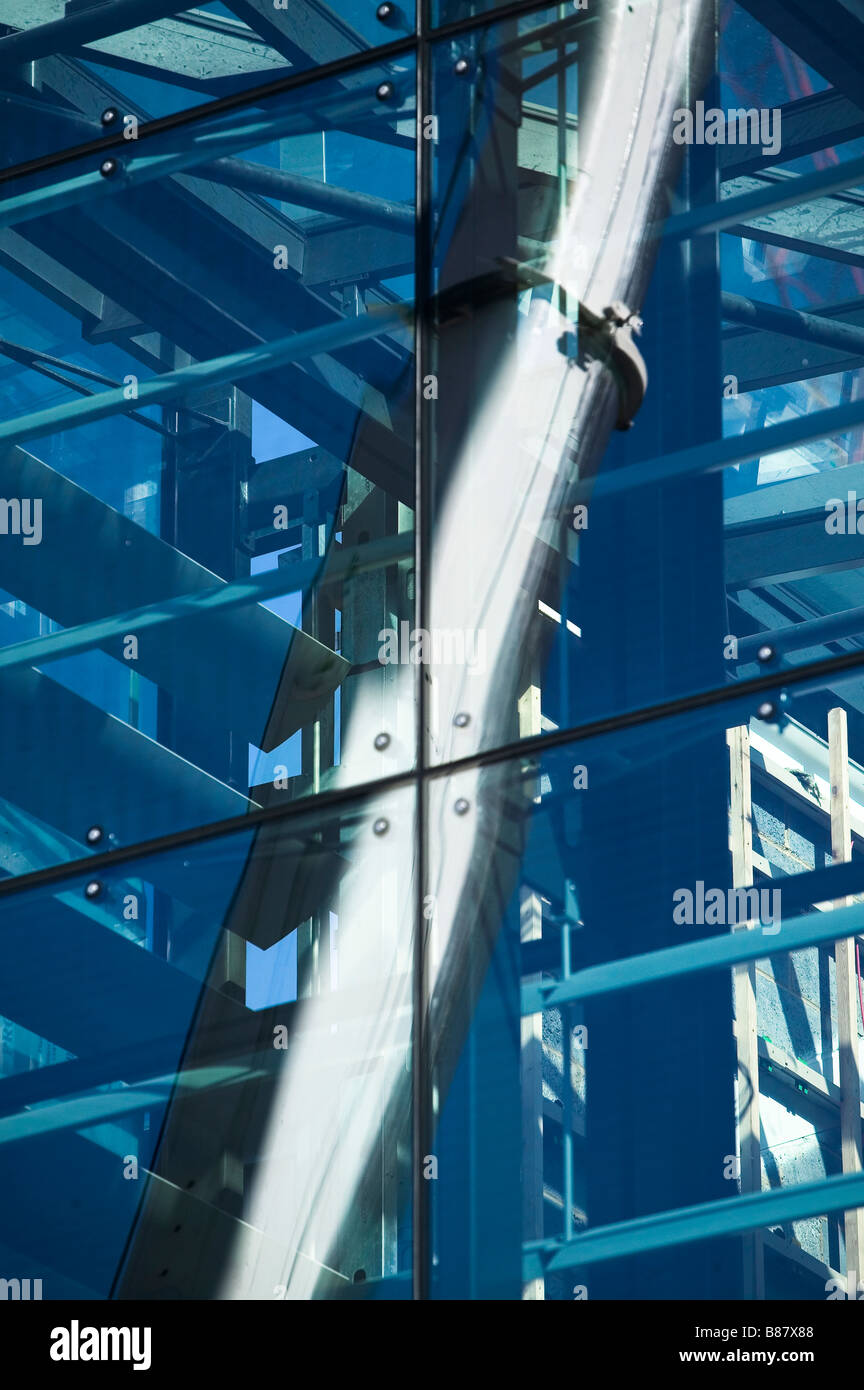 Flèche d'une grande grue mobile reflète dans la façade de verre de Jubilee library Brighton durant la construction. Banque D'Images