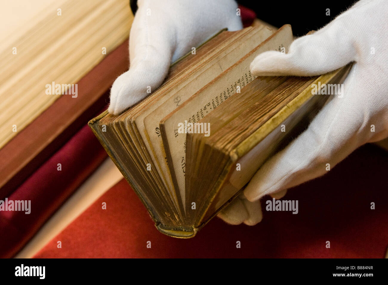 Livre rare étant détenu par personne portant des gants blancs bibliothèque Sussex Brighton Banque D'Images