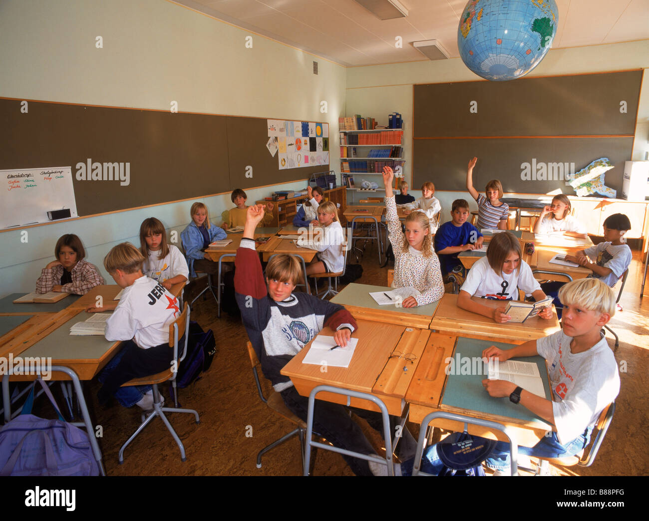 Les élèves de 5e année classe suédois assis à un bureau avec les mains posées au cours de séance de questions et réponses Banque D'Images
