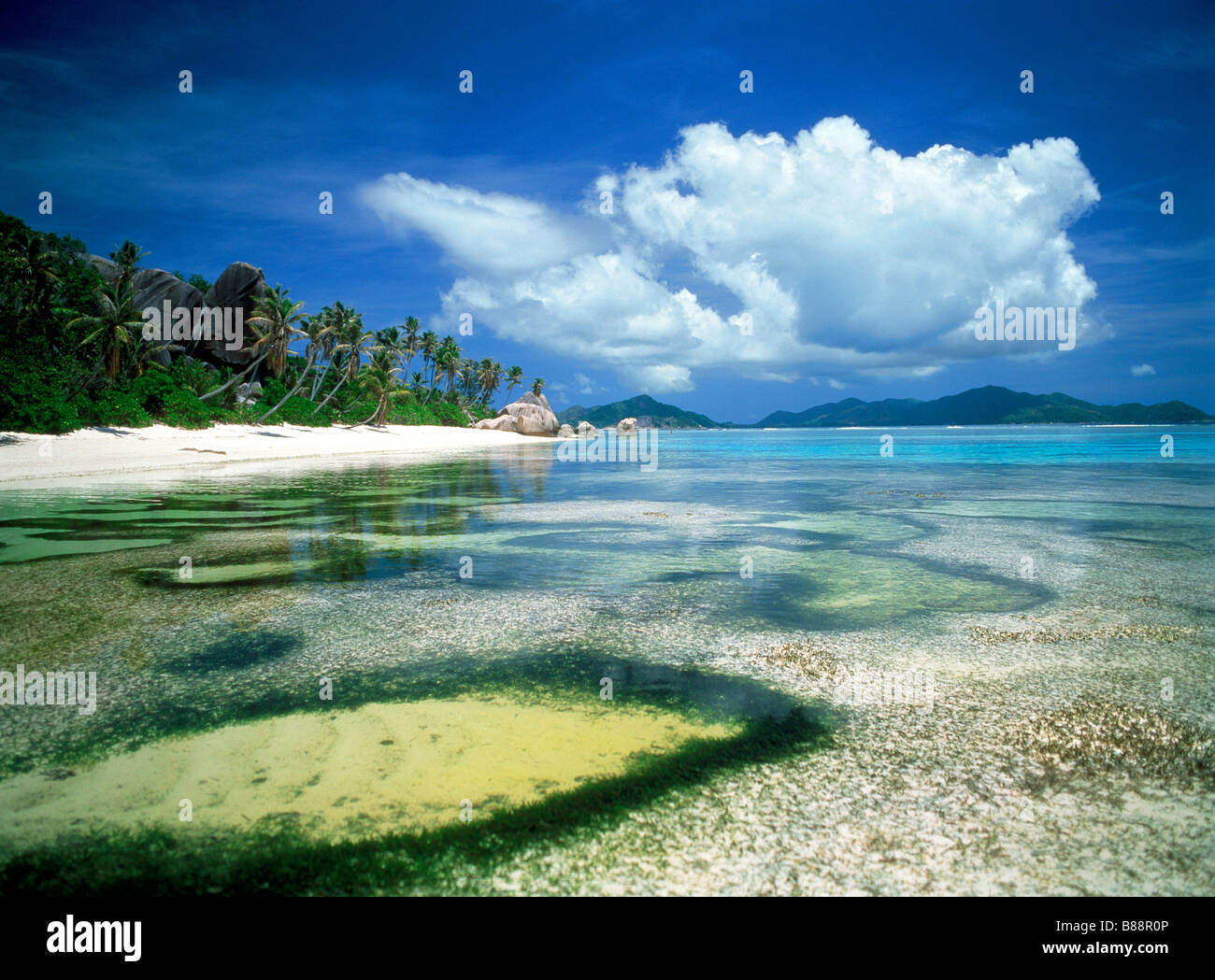 Nuages au-dessus des eaux peu profondes du lagon aqua à Anse Source d'argent sur l'île de La Digue aux Seychelles Banque D'Images