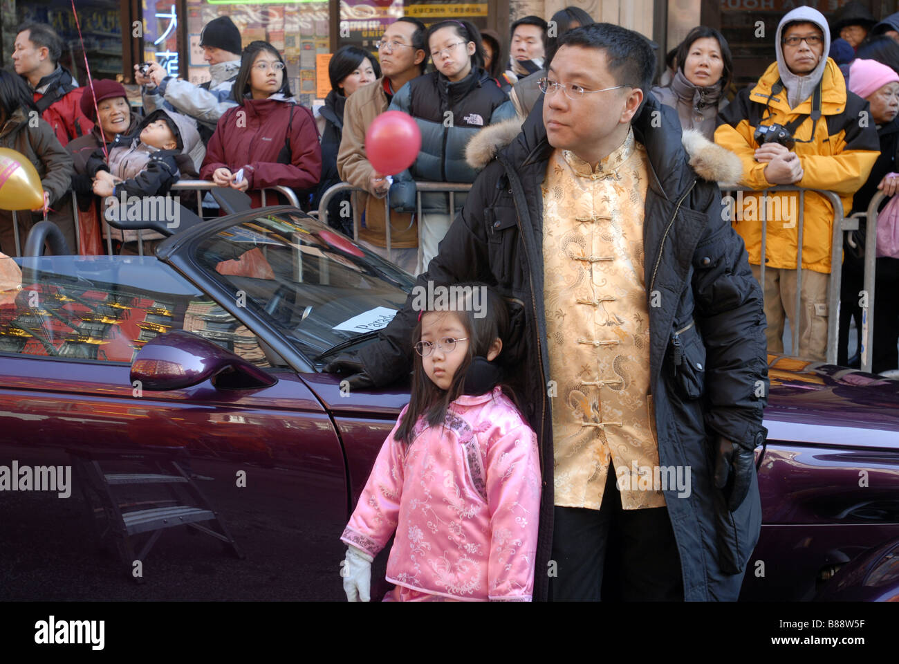 Un père et sa fille dans le quartier chinois attendre le Nouvel An lunaire chinois annuel défilé pour commencer à New York Banque D'Images