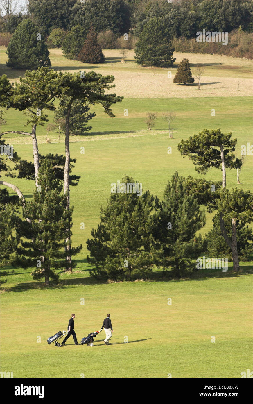 - Hillbarn les golfeurs tirant des chariots de golf, Worthing, West Sussex. Banque D'Images