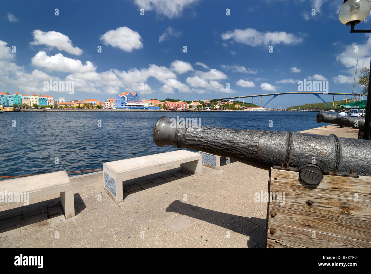 Vieux canons s'asseoir au bord de l'eau du quartier commerçant de Punda à Curaçao, Antilles néerlandaises, w Queen Juliana Bridge. Banque D'Images