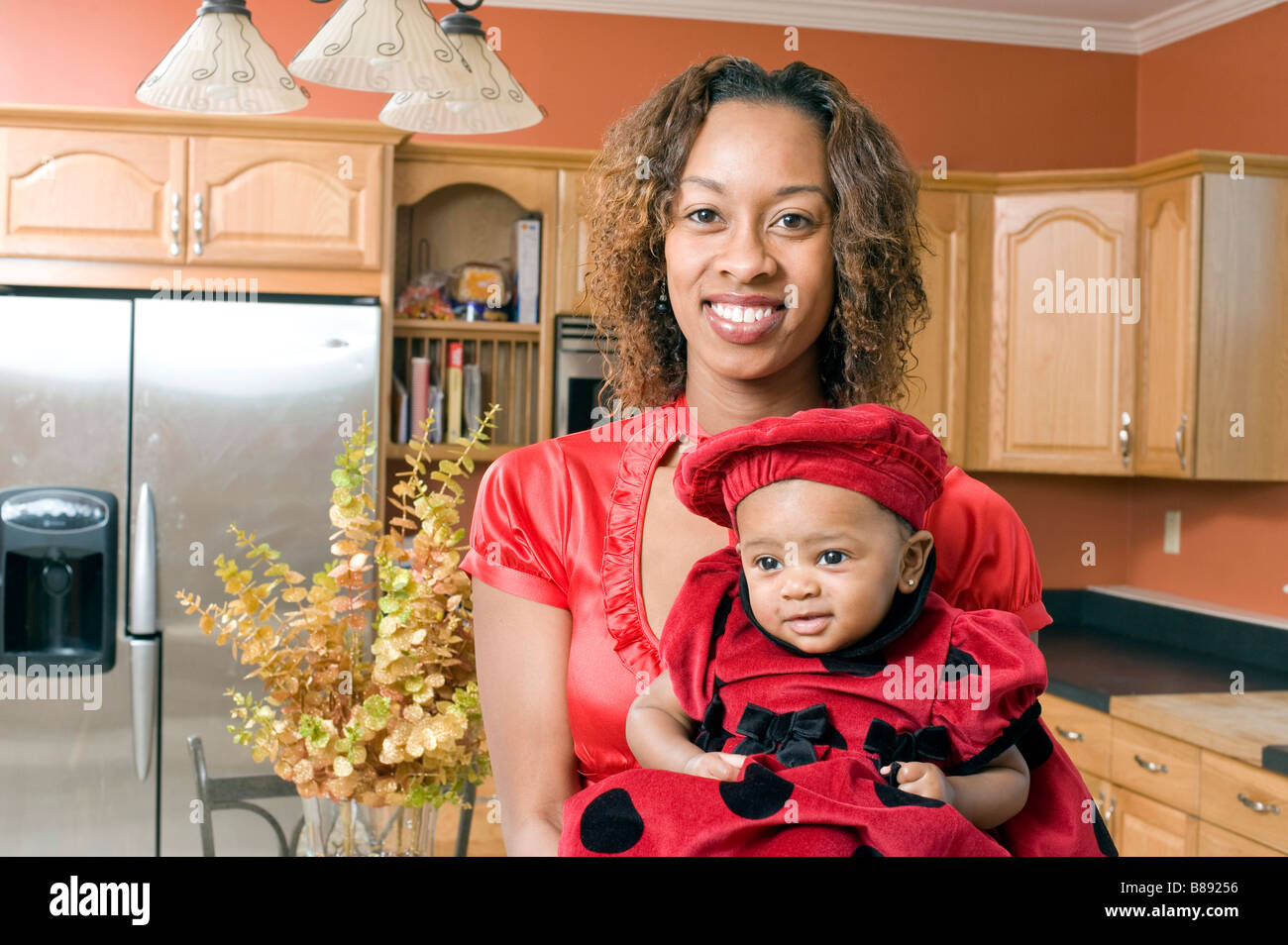 African American Woman pose avec sa petite fille dans la cuisine moderne entièrement rénové Banque D'Images