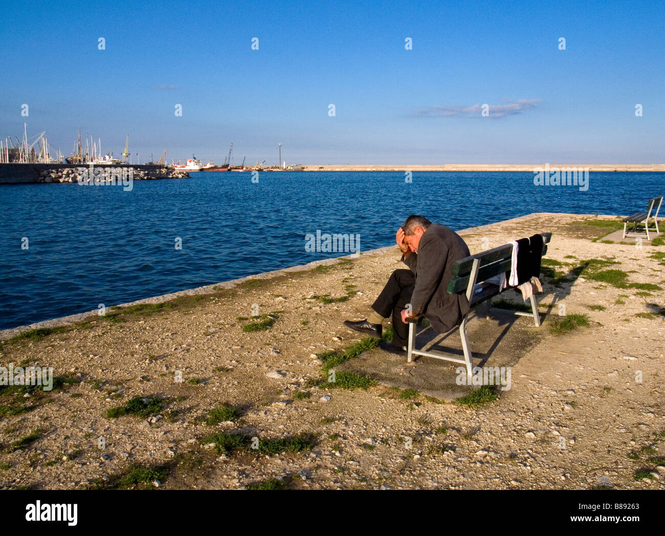 Homme assis sur un banc le long de la marina Palerme Sicile Italie Banque D'Images
