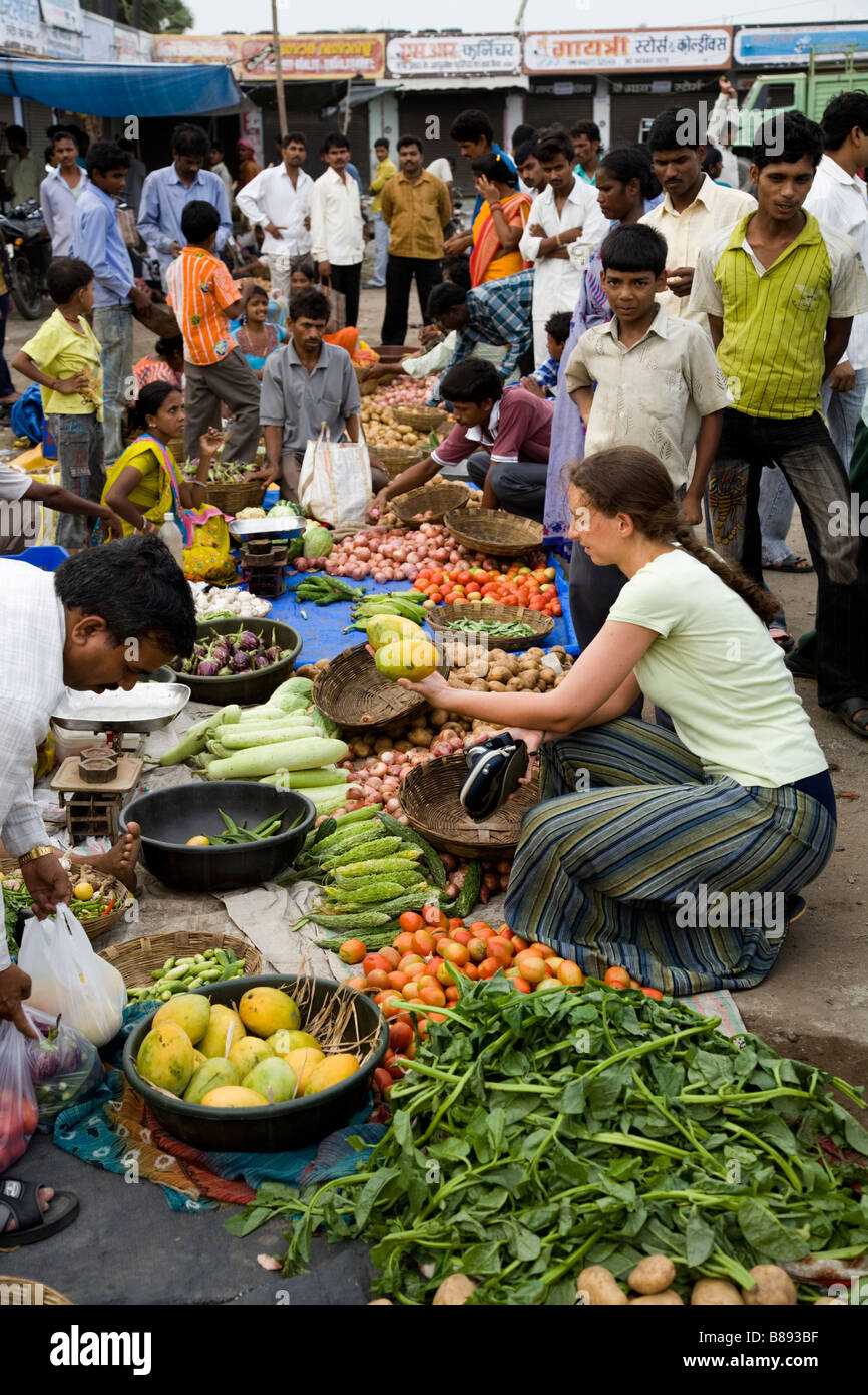 Femme de l'Ouest le choix et l'achat de tourisme les mangues au marché local, wc séparés. Hazira, Surat, Gujarat. L'Inde. Banque D'Images