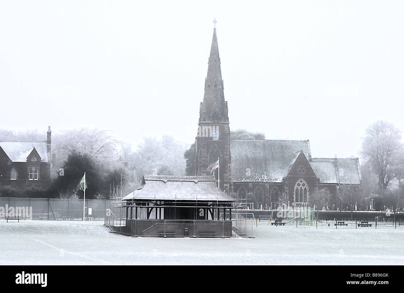 Une église et village green dans la neige Banque D'Images