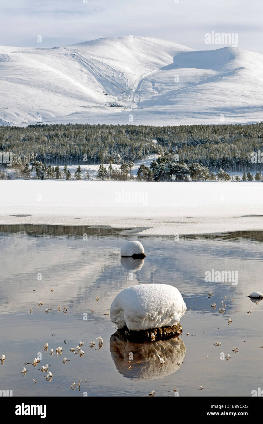 Les montagnes de Cairngorm de Loch Morlich congelé dans les contreforts de la neige couverts Parc National. 2122 SCO Banque D'Images