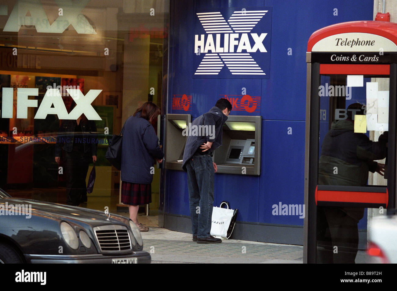 Les clients utilisant un guichet automatique au Halifax Bank à West Kensington Londres Banque D'Images