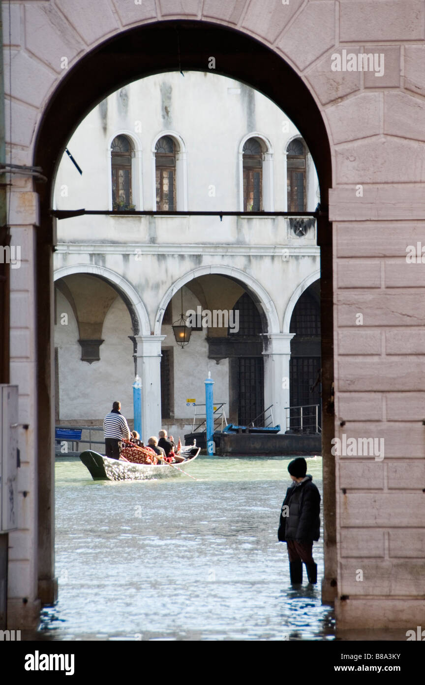 Gondole et le Poste Italiane à travers une arche de la Fabbriche Nuove di Rialto au cours aqua alta, Venise, Italie Banque D'Images