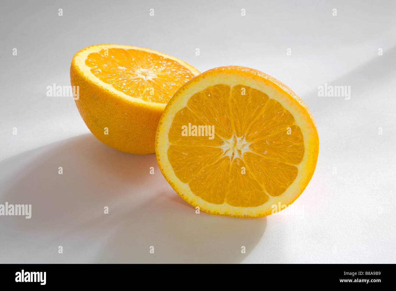 Nature morte de légumes fruits deux moitiés d'une orange Navel uniformément en tranches Banque D'Images