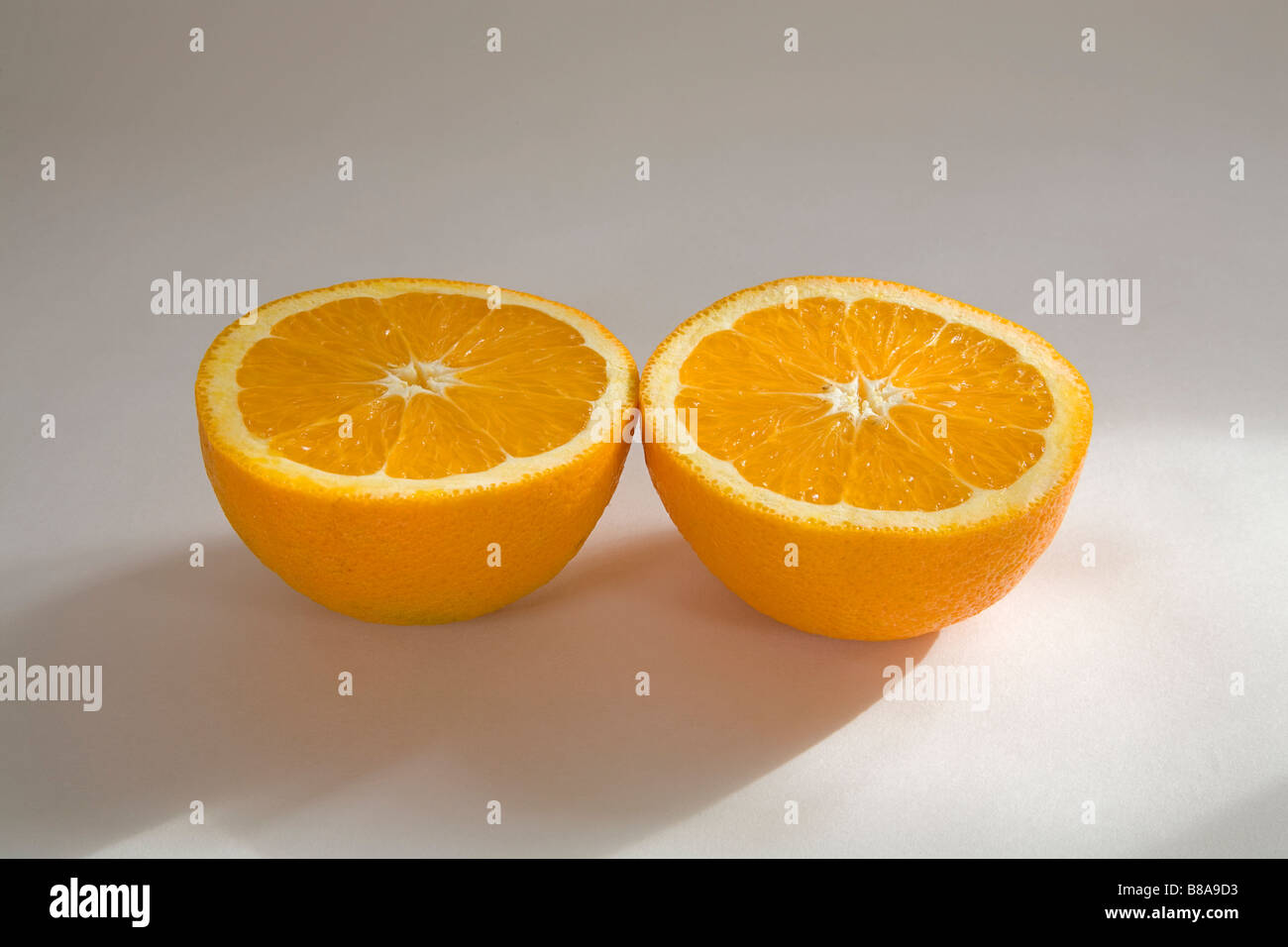 Nature morte de légumes fruits deux moitiés d'une orange Navel uniformément en tranches Banque D'Images