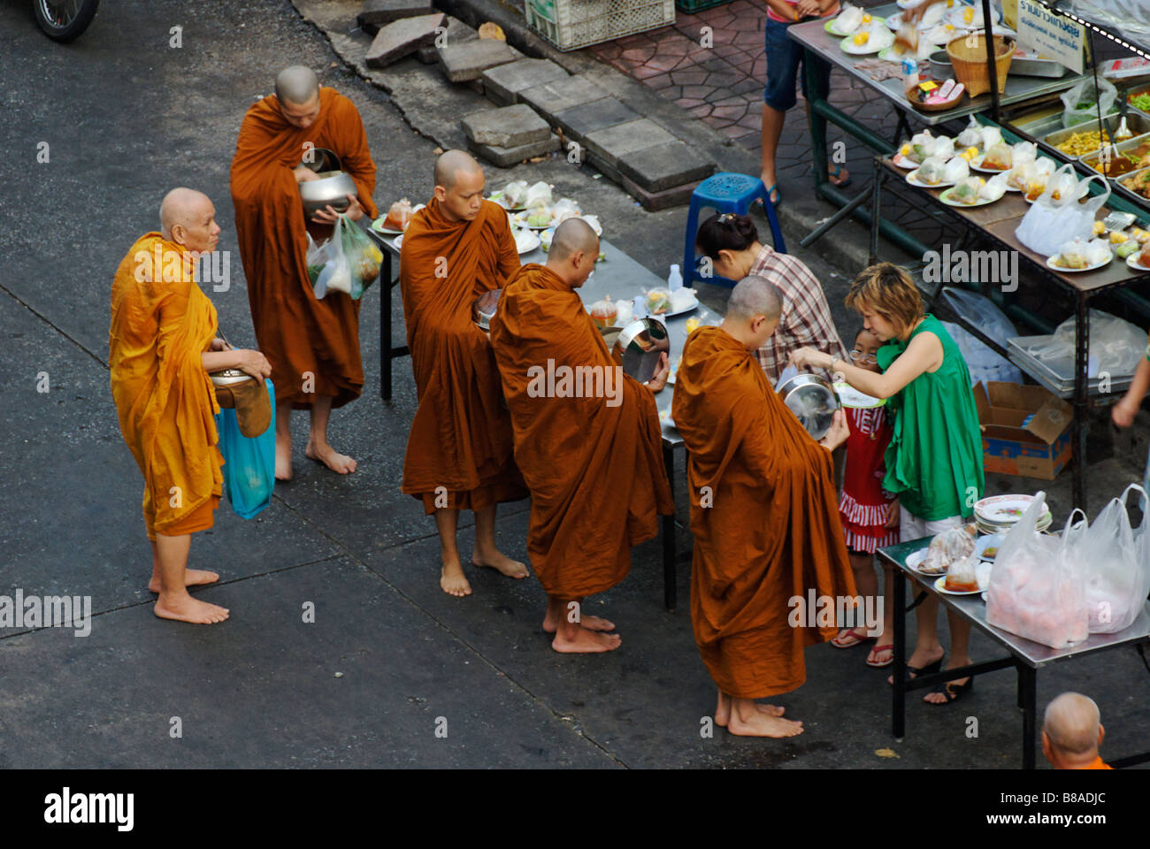 Les moines bouddhistes recevant l'aumône de nourriture tôt le matin, le centre de Bangkok Thaïlande Banglamphu Banque D'Images