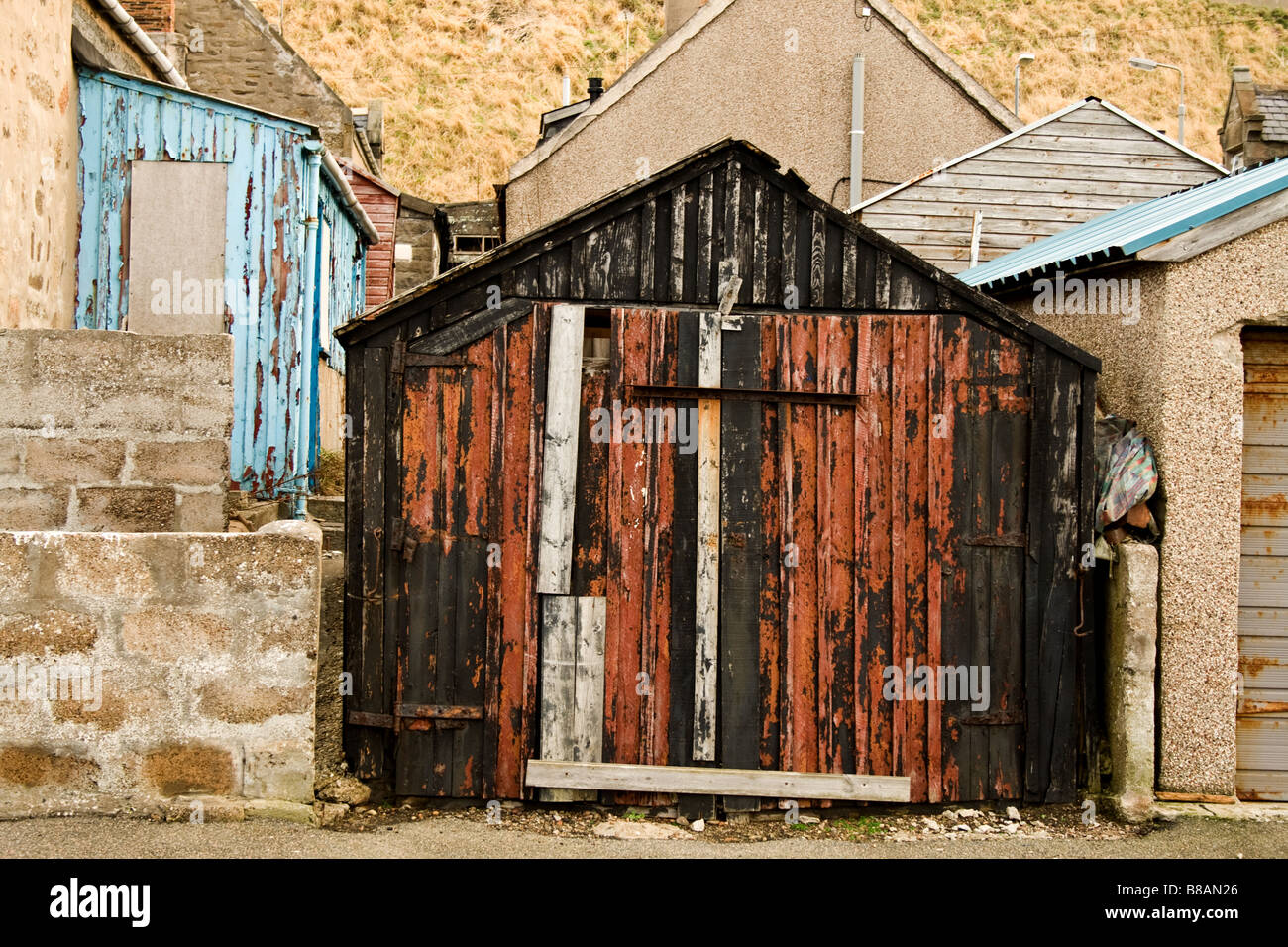 Weatherbeaten vieille cabane rouge et noir légèrement loucher à Buckie, Ecosse Banque D'Images