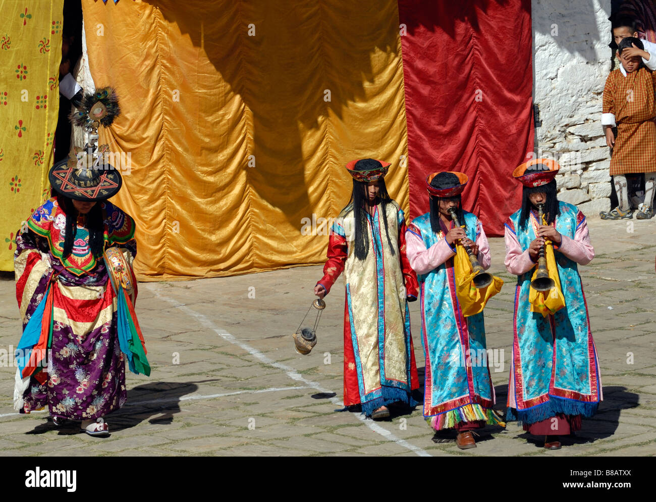 Accompagnement musiciens Danseurs au festival de Mongar, Mongar Tsechu. Les musiciens sont vêtus de robes de soie aux couleurs vives Banque D'Images