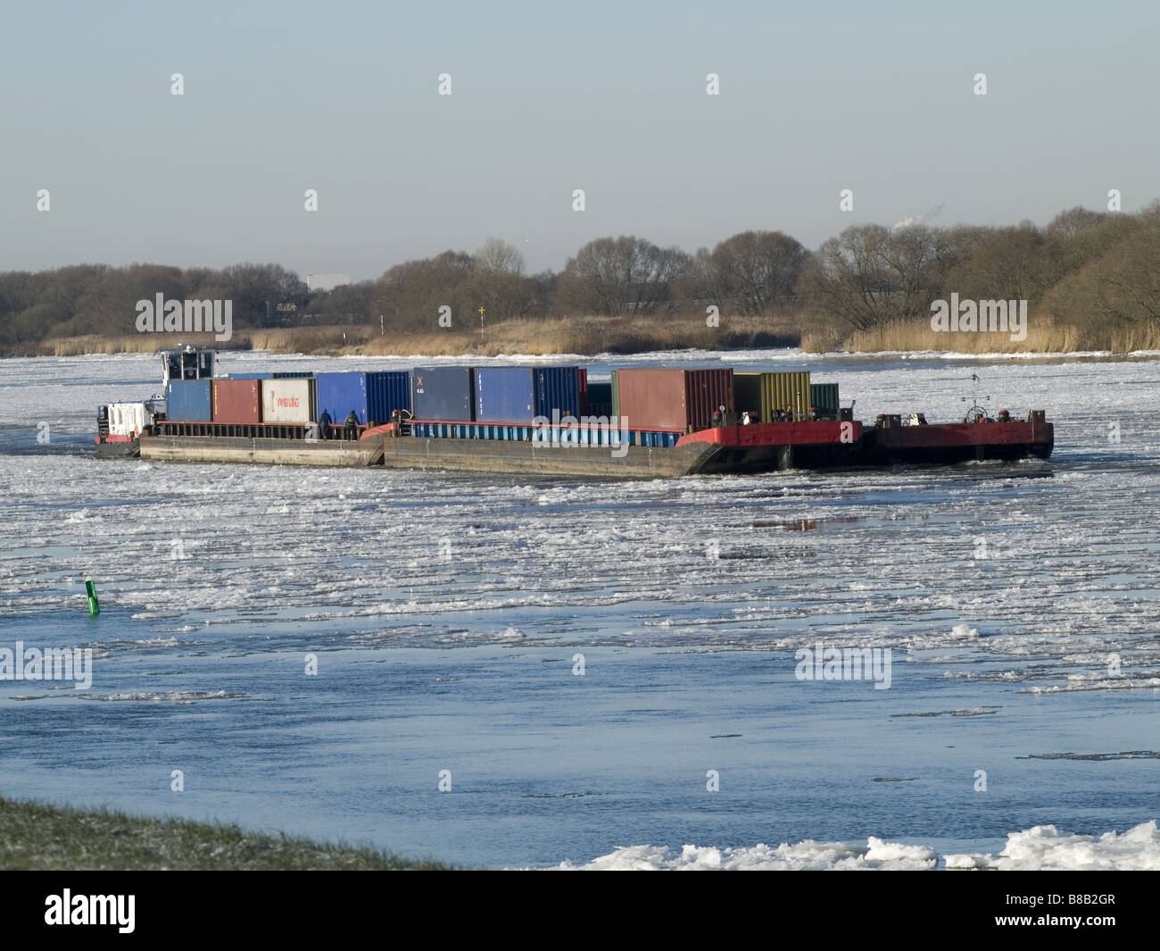 Pousser le remorquer avec des conteneurs sur les eaux glacées de l'Elbe en amont de voile. Banque D'Images