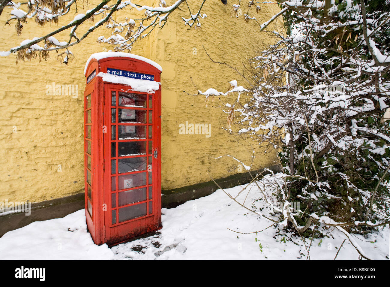 Uk téléphone rouge fort photographié sur un jour de neige. Banque D'Images