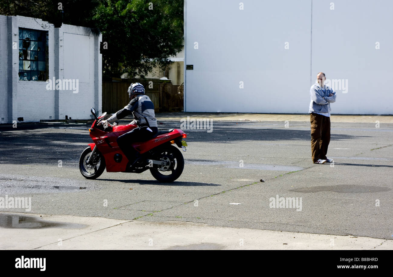 Les cercles d'un homme qu'il monte un test moto rouge. Banque D'Images