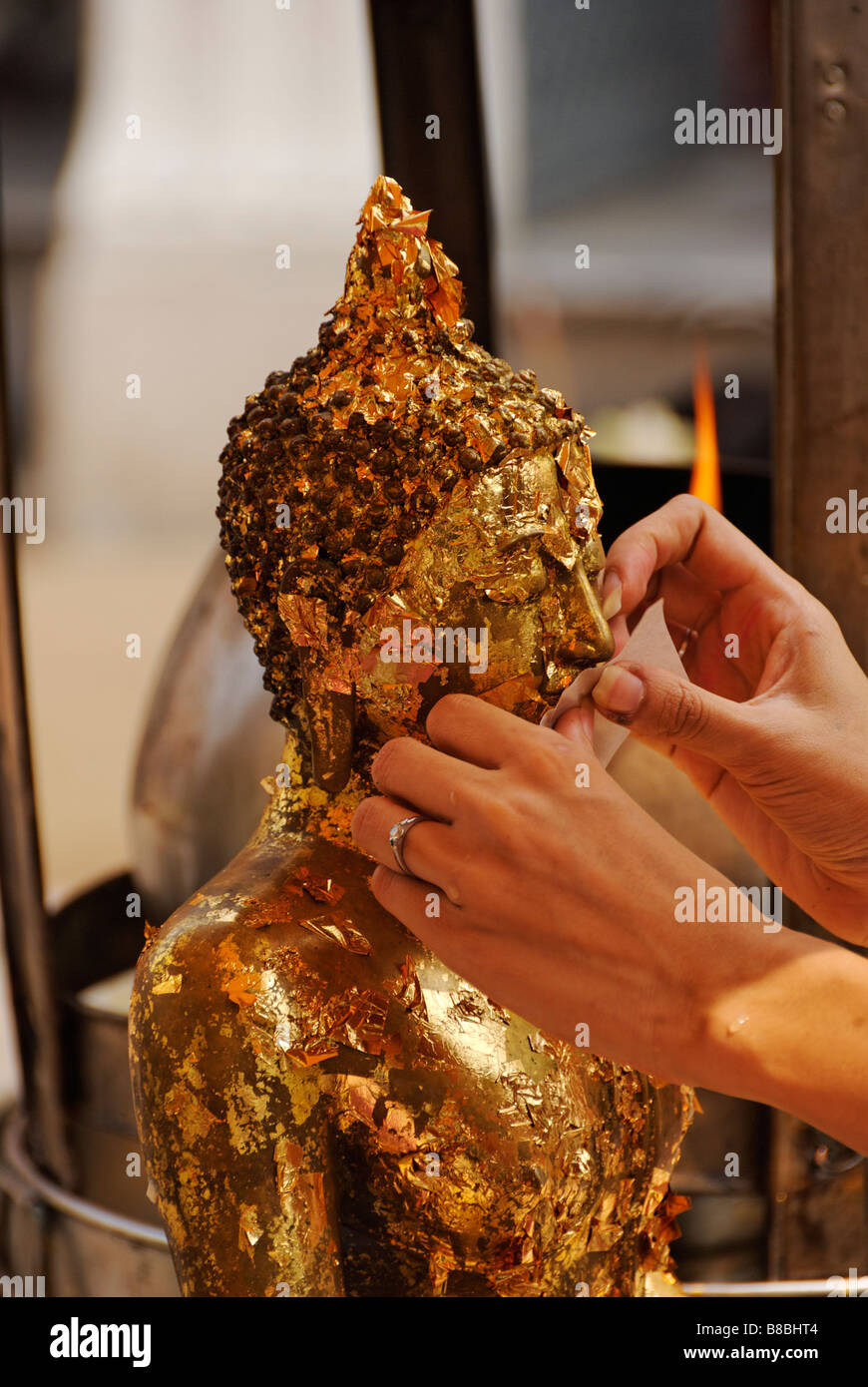 Personne qui demande la feuille d'or des offrandes à un bouddha statue - Wat Phra Kaew et le Grand Palais dans le centre de Bangkok en Thaïlande Banque D'Images