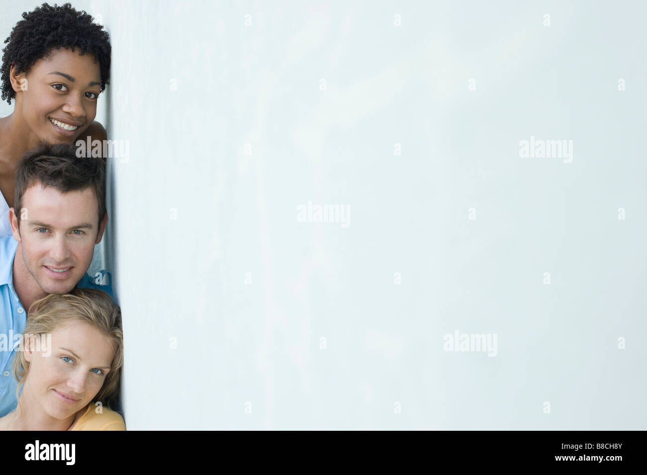 Trois amis adultes appuyé contre le mur et looking at camera Banque D'Images