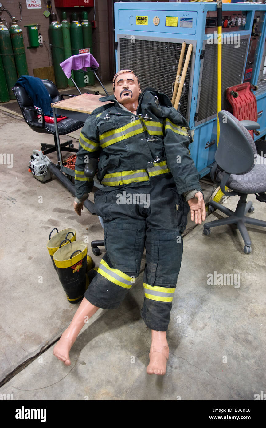 Un mannequin de formation des pompiers d'humour avec moustache et les cheveux tirés sur le port d'un feu de protection Banque D'Images