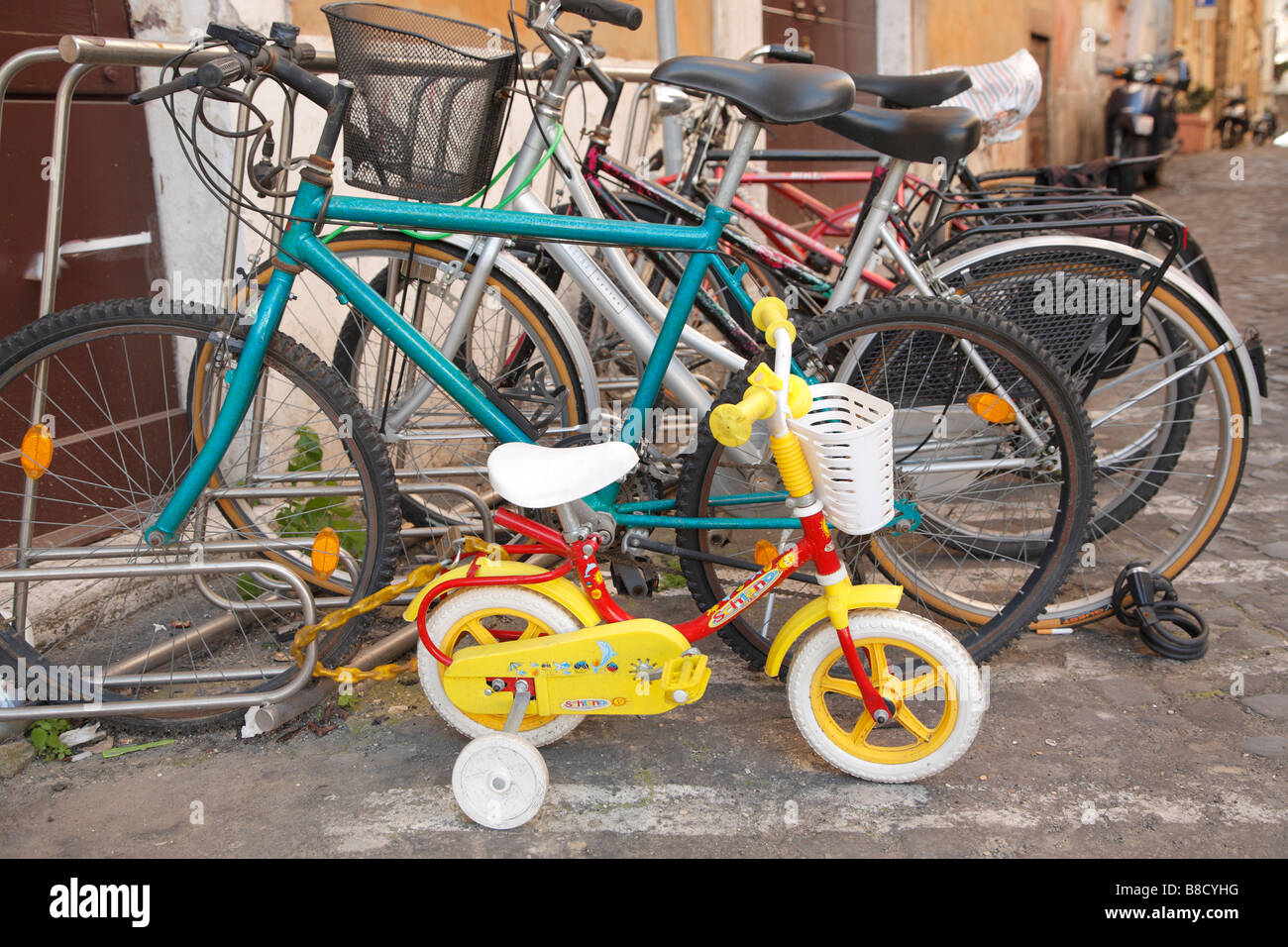 Vélo enfant verrouillé à côté de bicyclettes pour adultes, Rome, Italie Banque D'Images