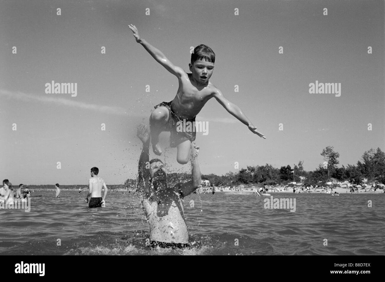 Boy Getting a lancé f épaules dans l'eau, le parc provincial de Grand Beach, au Manitoba Banque D'Images