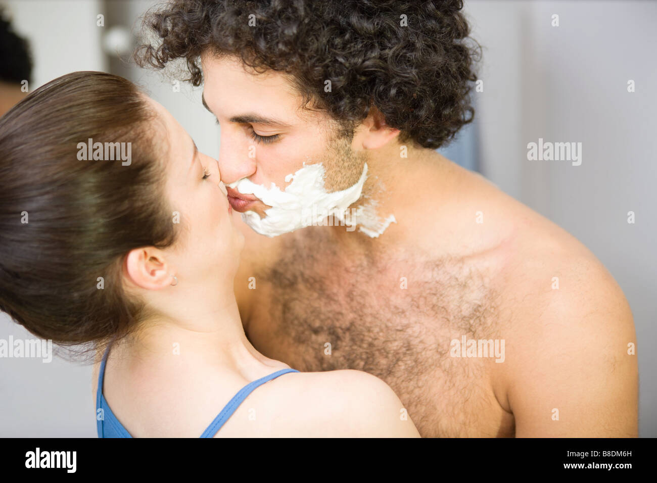 Woman kissing man avec mousse à raser Banque D'Images