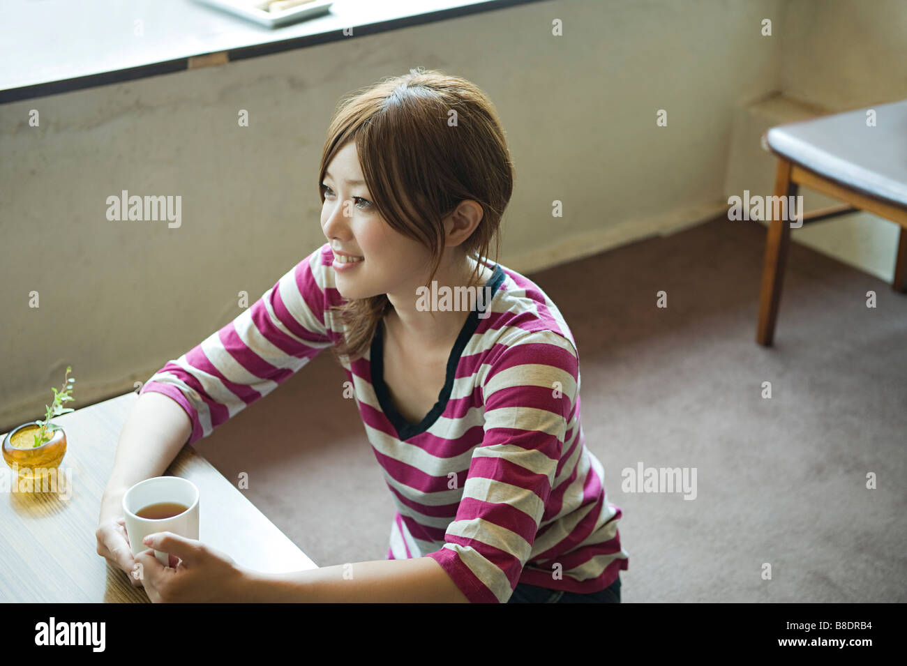 Jeune femme prenant le thé Banque D'Images