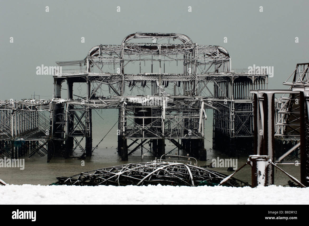 La neige recouvre la ruine de la jetée Ouest au large de la plage de Brighton, Sussex, sur une journée l'hiver. Banque D'Images