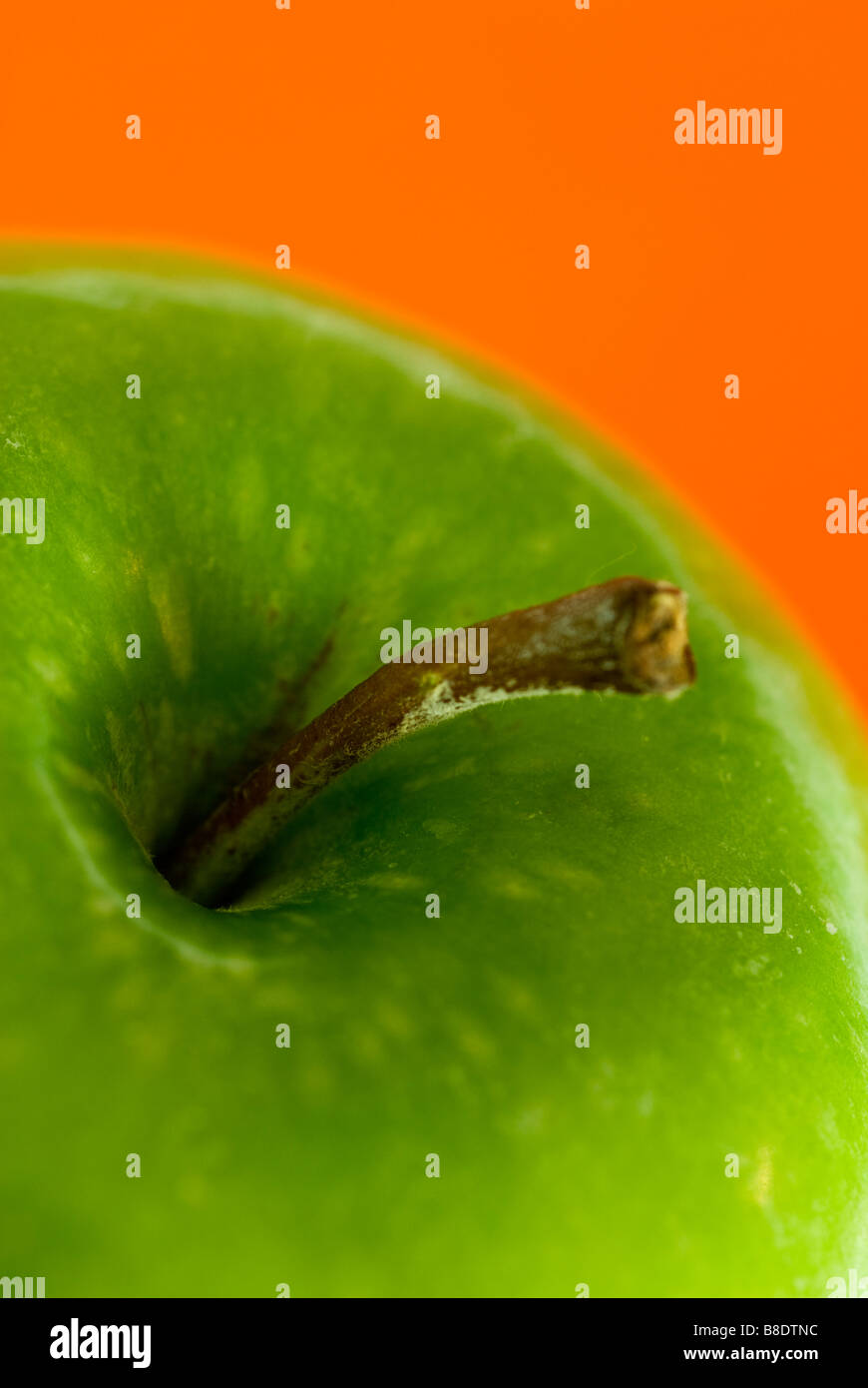 Pomme verte sur fond orange Banque D'Images